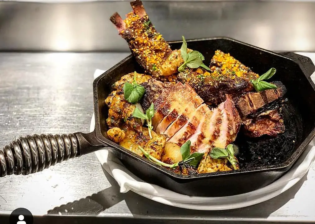 Heritage Breed Pork Tomahawk with Roasted Cippollini, Charred Sunchokes, Date Puree, Dukka Spice at Proof on Main Restaurant in Louisville